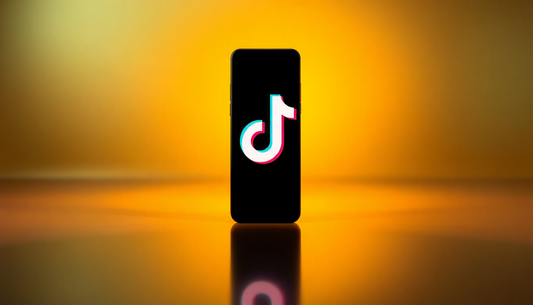 3D render of a smartphone showing the TikTok logo on a golden gradient background with glow and reflection.